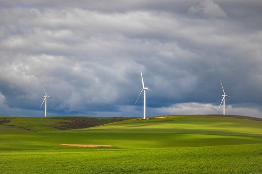 Dramatic thunderstorm over wind turbines in green fields - Caledon, Western Cape, South Africa.