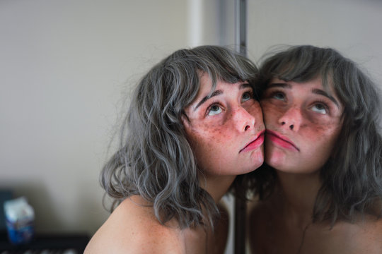 Naked woman with face on mirror