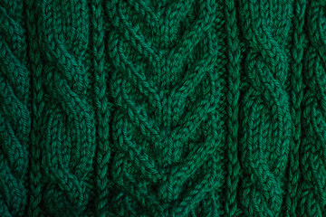 Texture of warm green knitted winter clothes.