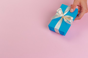 Woman holding gift box on color background