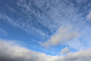 Naklejka na ściany i meble Fluffy white clouds against blue sky