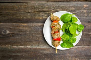 Raw skewers and vegetables on plate