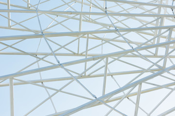 metallic parts of observation wheel construction against blue sky