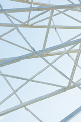 metallic parts of observation wheel construction against blue sky in amusement park