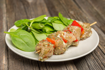 Raw skewers and vegetables on plate