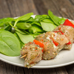 Raw skewers and vegetables on plate