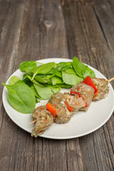 Raw skewers and vegetables on plate