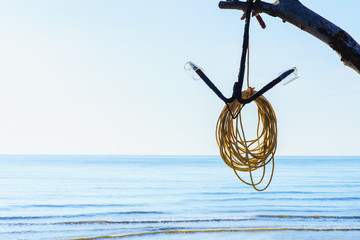 Old rusty anchor with string hanging on tree branch with beautiful sea and blue sky. Summer holiday concept background with copy space. © picment