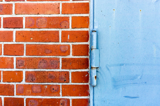 Close-Up of a door hinge and Brick Wall