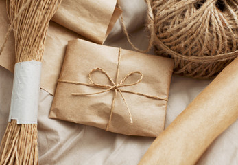 Craft paper package with roll of rope. Hand made present. Parcel to send. Decorative design for gifts.
