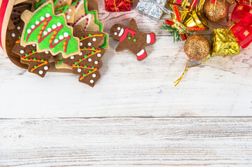 Beautiful Christmas composition and decoration with baked Christmas gingerbread cookies in paper bag on light wooden background, flat lay, top view, copy space (text space)