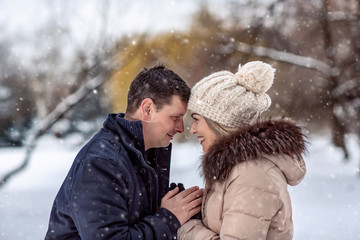 Obraz premium Loving couple enjoying together during winter holidays vacation outside in snow park.