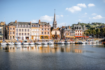 Waterside with ancient buildings and church in Honfleur, famous french town in Normandy