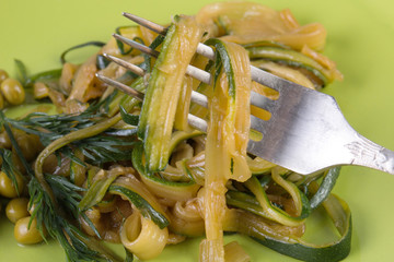 Spiraled zucchini pasta with peas. Vegitarian food close up