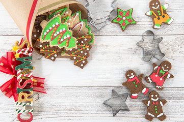 Beautiful Christmas composition and decoration with baked Christmas gingerbread cookies in paper bag on light wooden background, flat lay, top view, copy space (text space)