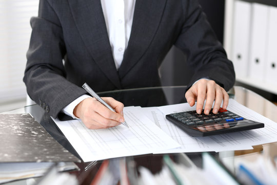 Bookkeeper woman or financial inspector  making report, calculating or checking balance, close-up. Business portrait. Copy space area for audit or tax concepts