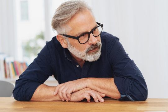 Middle-aged bearded man sitting at table