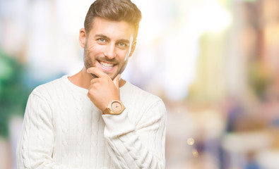 Young handsome man wearing winter sweater over isolated background looking confident at the camera with smile with crossed arms and hand raised on chin. Thinking positive.