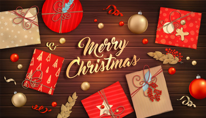 Merry Christmas and happy new year. Beautiful background with Christmas decoration: red and gold balls, craft gift boxes, ribbons and branch of Holly on wooden backdrop. Xmas holiday greeting card