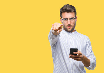 Young handsome man texting using smartphone over isolated background pointing with finger to the camera and to you, hand sign, positive and confident gesture from the front