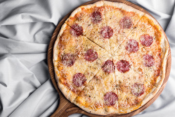 Fresh pizza with pepperoni, cheese and tomato sauce and