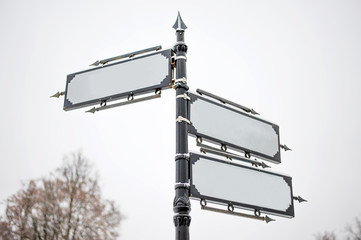 a metal pole with three vintage style signs