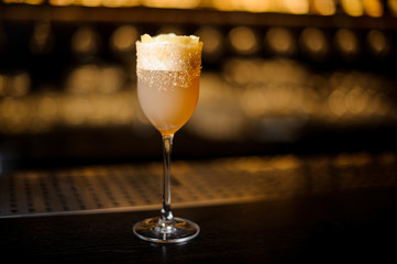 Sweet wine glass filled with delicious brandy crusta cocktail on the bar counter