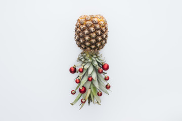 top view of red christmas balls on fresh pineapple isolated on white
