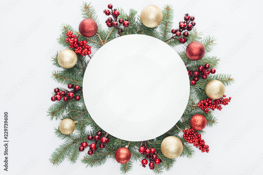 Wall mural top view of pine tree wreath with christmas decorations and round blank space in middle isolated on 