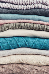 Stack of knitted casual clothes various colors and textures