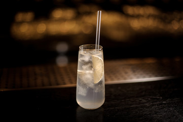 Elegant long drink glass filled with Tom Collins cocktail on the bar