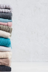 Light background with stack of knitted casual clothes various colors and textures