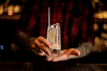 Man holding elegant long drink glass filled with Tom Collins cocktail