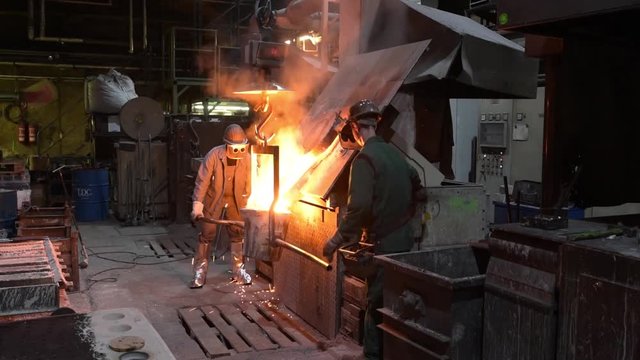 casting a metal workpiece - workers in a foundry // giessen einen Werkst&uuml;ckes aus Metall - Arbeiter in einer Giesserei 