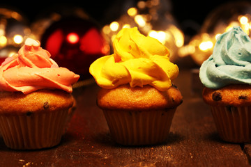 Tasty cupcakes on christmas winter background. Birthday cupcake in rainbow colors.