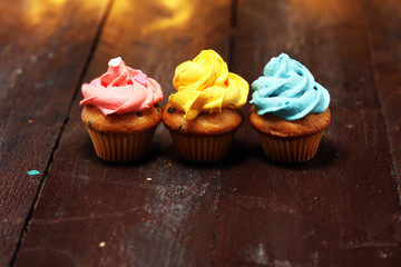 Tasty cupcakes on christmas winter background. Birthday cupcake in rainbow colors.