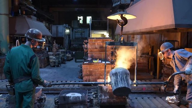 casting a metal workpiece - workers in a foundry // giessen einen Werkst&uuml;ckes aus Metall - Arbeiter in einer Giesserei 
