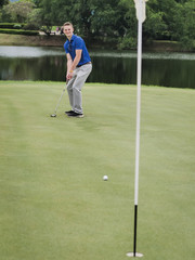 Obraz premium Golfer putting golf ball on the green golf in cloudy day.