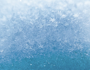 Snow texture with snowflakes close-up. Beautiful winter and Christmas background. Blue macro image of an abstract snowdrift.