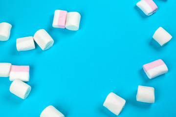 marshmallow laid out on blue paper background. pastel creative textured pattern.