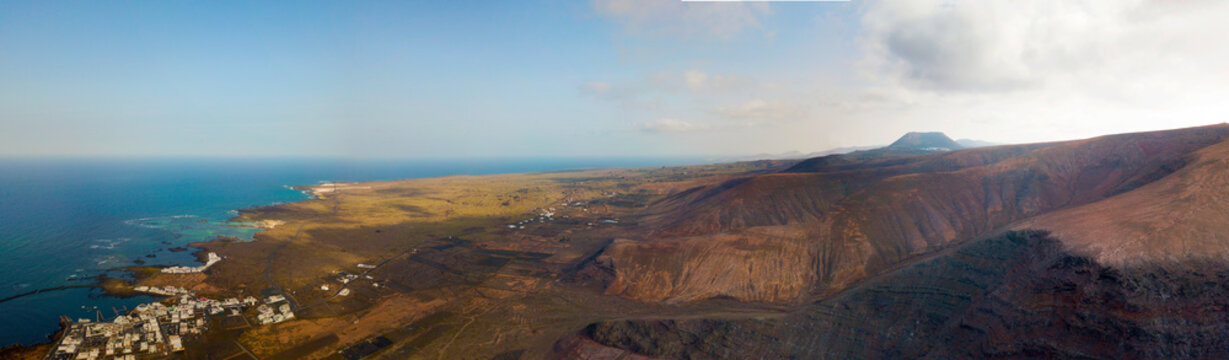 Vista aerea del paese di Orzola e delle coste frastagliate dell&rsquo;isola di Lanzarote, Isole Canarie, Spagna. Africa. Rilievi a picco sul mare e percorsi sterrati. Sentieri per trekking