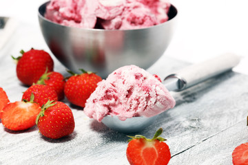 Strawberry ice cream scoop with chopped nuts and white chocolate on a rustic background
