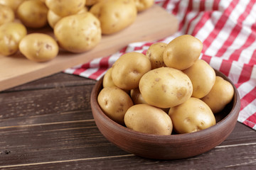 Fresh potatoes on the wood background