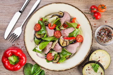 Fresh salad with ham, red pepper, eggplant and basil leaves