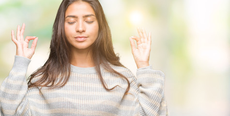 Young beautiful arab woman wearing winter sweater over isolated background relax and smiling with eyes closed doing meditation gesture with fingers. Yoga concept.