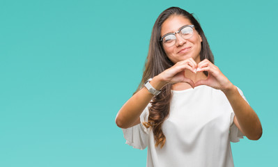 Fototapeta premium Young beautiful arab woman wearing glasses over isolated background smiling in love showing heart symbol and shape with hands. Romantic concept.