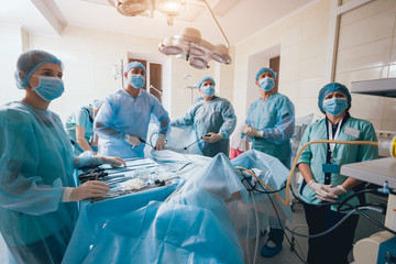 Process of gynecological surgery operation using laparoscopic equipment. Group of surgeons in operating room with surgery equipment - obrazy, fototapety, plakaty
