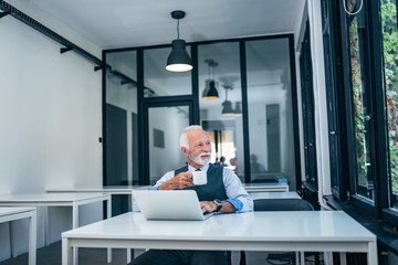 Senior businessman drinking tea or coffee at work.
