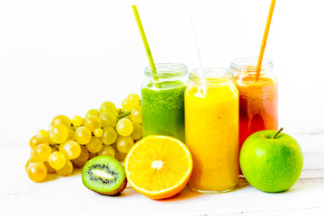 Fresh detox juices in glass bottles on white background