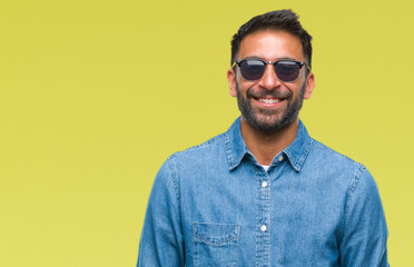 Adult hispanic man wearing sunglasses over isolated background with a happy and cool smile on face....